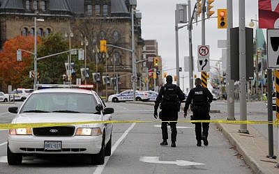 Ottawa police officers walk near the National War Memorial where a soldier was shot just blocks away from Parliament Hill, on October 22, 2014 in Ottawa, Canada. (photo credit: Mike Carroccetto/Getty Images/AFP)