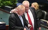 Rob Ford (right) talks to his brother Doug Ford in the Toronto council chamber, November, 2013 (photo credit: AP/The Canadian Press/ Chris Young)