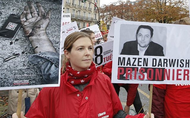 Lucie Morillon, head of research at French watchdog Reporters without Borders, holds a banner depicting Syrian human rights activist Mazen Darwish during a protest against violence in Syria, in Paris, Saturday, October 20, 2012. (photo credit: AP/Francois Mori)