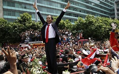 Indonesian President Joko Widodo gestures to the crowd during a street parade following his inauguration in Jakarta, Indonesia, Monday, Oct. 20, 2014. (photo credit: AP Photo/Achmad Ibraham)