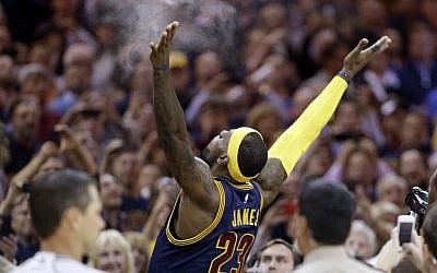 Cleveland Cavaliers' LeBron James tosses chalk in the air before the start of an NBA basketball game against the New York Knicks in Cleveland, on Thursday, October 30, 2014. (photo credit: AP/Tony Dejak)