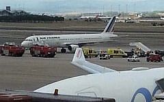 Illustrative image of emergency crews standing next to a plane, carrying 163 people, at the Madrid Airport, Spain, October 16, 2014. (AP/Antoni Manchado)