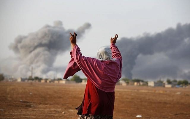 A Syrian Kurd gestures as thick smoke rises following an airstrike by the US-led coalition in Kobani, on Monday, October 13, 2014. (photo credit: AP Photo/Lefteris Pitarakis) A Syrian Kurd gestures as thick smoke rises following an airstrike by the US-led coalition in Kobani, on Monday, October 13, 2014. (photo credit: AP Photo/Lefteris Pitarakis)