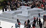 People surround a memorial dedicated to deserters of the Nazi Wehrmacht troops and victims of their military justice during its unveiling ceremony in downtown Vienna, Austria, Friday, October 24, 2014 (Photo credit: Ronald Zak/AP)