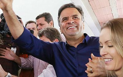 In this photo released by Coligacao Muda Brasil, presidential candidate Aecio Neves and his wife Leticia Weber campaign during general elections in Belo Horizonte, Brazil, Sunday, Oct. 5, 2014. (AP Photo/Marcos Fernandes-Coligacao Muda Brasil)