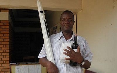 Shmuel Mugisha of the Abayudaya Jewish community in Uganda picks up the emergency lulav in Kampala, just a few hours before the holiday began. (Melanie Lidman/Times of Israel)