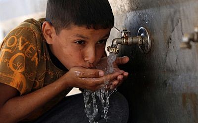 A Palestinian child drinking water at UNRWA headquarters in Khan Yunis refugee camp, in the Gaza Strip, April 24, 2010 (Photo: Abed Rahim Khatib / Flash 90)