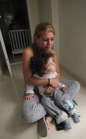 A mother hugs her child as they sit in the safe zone while a siren sounds in the town of Ashkelon, November 18, 2012 (photo credit: Yossi Zamir/Flash90)