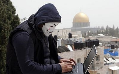 A Palestinian in a Guy Fawkes mask on a computer in Jerusalem, April 8, 2013. (photo credit: Sliman Khader/Flash90)