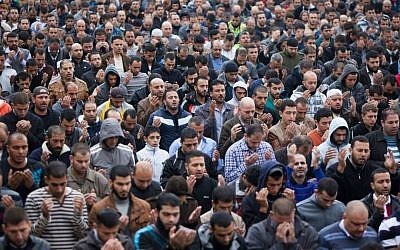 Palestinians pray as Israeli policemen guard (unseen) during Friday prayers in the East Jerusalem neighborhood of Wadi Joz, October 31, 2014. (Yonatan Sindel/Flash90)