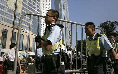 Police officers remove some barricades used by pro-democracy protesters who have been occupying main roads in the Asian financial center for two weeks in Hong Kong, Monday, Oct. 13, 2014. (photo credit: AP/Vincent Yu)