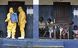 Illustrative photo of health officials disinfecting a room that had been inhabited by suspected Ebola in Liberia, on September 30, 2014. (photo credit: AP/Jerome Delay, File)
