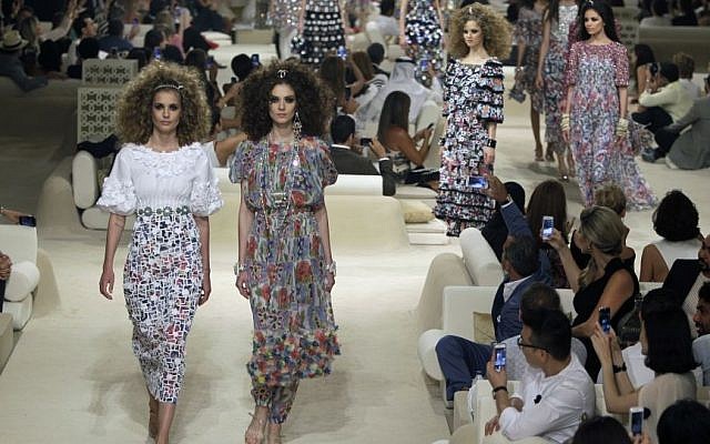 In this Tuesday, May 13, 2014 file photo, models walk among the guests at the Chanel Cruise Dubai show revealing the French Maison's new Cruise collection for the 2014/15 season, staged on a private island in Dubai, United Arab Emirates. (Photo credit: AP/Kamran Jebreili-file)