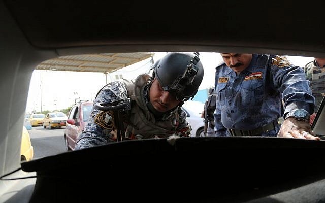 Iraqi federal policemen search a car at a checkpoint in Baghdad, Iraq, Saturday, Oct. 11, 2014. (photo credit: AP Photo/Karim Kadim) Iraqi federal policemen search a car at a checkpoint in Baghdad, Iraq, Saturday, Oct. 11, 2014. (photo credit: AP Photo/Karim Kadim)