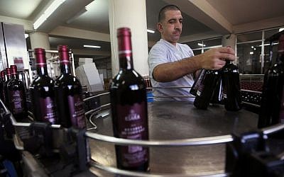 A Lebanese worker arranges Ksara red wine bottles at Chateau Ksara winery complex in the Bekaa valley, east Lebanon, in September, 2014. (photo credit: AP Photo/Hussein Malla)