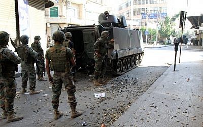 Lebanese Army soldiers stand beside an armored vehicle during clashes with Islamic militants, in the northern port city of Tripoli, Lebanon, on Saturday, October 25, 2014. (photo credit: AP)