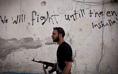 A Free Syrian Army fighter walks through a street in the Amariya district of Aleppo, Syria, on September 10, 2012. (photo credit: AP/Manu Brabo, File)