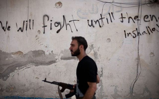 A Free Syrian Army fighter walks through a street in the Amariya district of Aleppo, Syria, on September 10, 2012. (photo credit: AP/Manu Brabo, File) A Free Syrian Army fighter walks through a street in the Amariya district of Aleppo, Syria, on September 10, 2012. (photo credit: AP/Manu Brabo, File)