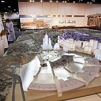 In this photo taken May 11, 2014, Essam Kalthoum, left, managing director of the Bawabat Makkah Company, which oversees several projects around the city, shows at his office in Jiddah, Saudi Arabia, a prototype of what the heart of Mecca will look like after construction around the Grand Mosque is complete. (photo credit: AP/Hasan Jamali)