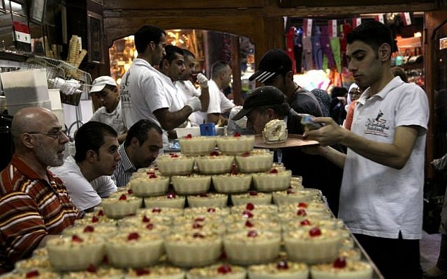 Waiters prepare deserts in Bekdash, an ice-cream shop considered to make the finest Levantine gelato in the ancient bazaar known as the Hamdiyeh souq, in Damascus, Syria, Monday, Oct. 27, 2014. (photo credit: AP/Diaa Hadid) Waiters prepare deserts in Bekdash, an ice-cream shop considered to make the finest Levantine gelato in the ancient bazaar known as the Hamdiyeh souq, in Damascus, Syria, Monday, Oct. 27, 2014. (photo credit: AP/Diaa Hadid)