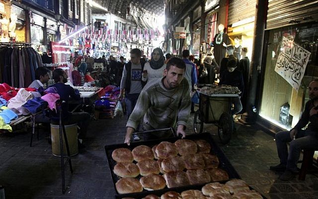 A bread seller pushes his wares through the ancient bazaar known as the Hamidiyeh souq in Damascus, Syria, Monday, Oct. 27, 2014. (photo credit: AP/Diaa Hadid) A bread seller pushes his wares through the ancient bazaar known as the Hamidiyeh souq in Damascus, Syria, Monday, Oct. 27, 2014. (photo credit: AP/Diaa Hadid)