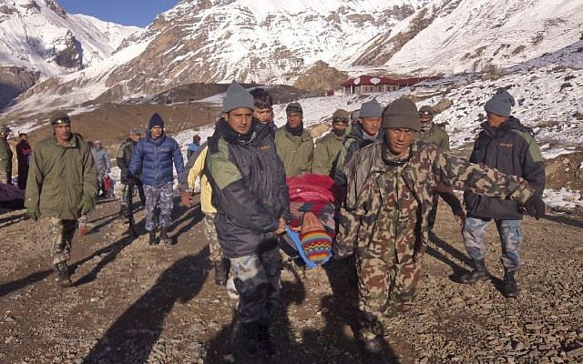 Nepalese Army soldiers carry an avalanche victim before he is airlifted in Thorong La pass area, Nepal, Wednesday, October 15, 2014. (photo credit: AP/Nepalese Army)