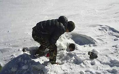 A Nepalese army soldier searches for avalanche victims at Thorong La pass area in Nepal, Sunday, Oct. 19, 2014. Nepalese officials closed a section of a popular Himalayan trekking route Sunday after rescuers, overwhelmed with last week's snowstorms that killed 38 hikers, had to bring to safety new climbers who set out on the same mountain trails where the blizzards struck. (photo credit: AP Photo/Nepalese Army)