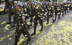 Confetti rains on marching Filipino UN peacekeepers as they are given a hero's welcome Wednesday, Oct. 1, 2014, at Camp Aguinaldo in the Philippines. (photo credit: AP/Bullit Marquez)