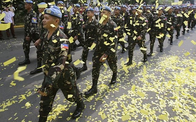 Confetti rains on marching Filipino UN peacekeepers as they are given a hero's welcome Wednesday, Oct. 1, 2014, at Camp Aguinaldo in the Philippines. (photo credit: AP/Bullit Marquez) Confetti rains on marching Filipino UN peacekeepers as they are given a hero's welcome Wednesday, Oct. 1, 2014, at Camp Aguinaldo in the Philippines. (photo credit: AP/Bullit Marquez)