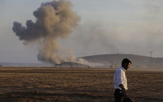 A Turkish Kurd walks away as airstrikes hit Kobani, inside Syria, as fighting intensifies between Syrian Kurds and the militants of Islamic State group, in Mursitpinar, on the outskirts of Suruc, at the Turkey-Syria border, Wednesday, Oct. 8, 2014. (Photo credit: AP/Lefteris Pitarakis) A Turkish Kurd walks away as airstrikes hit Kobani, inside Syria, as fighting intensifies between Syrian Kurds and the militants of Islamic State group, in Mursitpinar, on the outskirts of Suruc, at the Turkey-Syria border, Wednesday, Oct. 8, 2014. (Photo credit: AP/Lefteris Pitarakis)