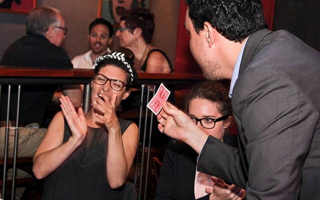 Magician Ran Gafner performs a close-up trick at a patron's table. (photo credit: photo by Shivi Isman) Magician Ran Gafner performs a close-up trick at a patron's table. (photo credit: photo by Shivi Isman)