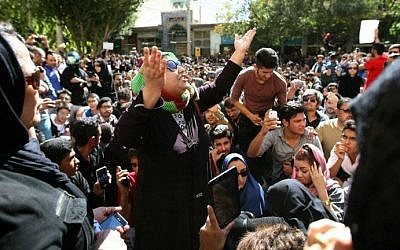 ILLUSTRATIVE PHOTO: Iranians take part in a protest in front of the judiciary building on October 22, 2014 in Isfahan,  in solidarity with women injured in a series of acid attacks (photo credit: AFP PHOTO/ISNA/Arya Jafari)