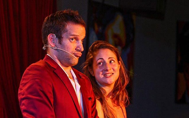 Itai Pinki performs a combination of comedy and magic on stage with a guest from the audience. (photo credit: courtesy Sorcerers' Night)