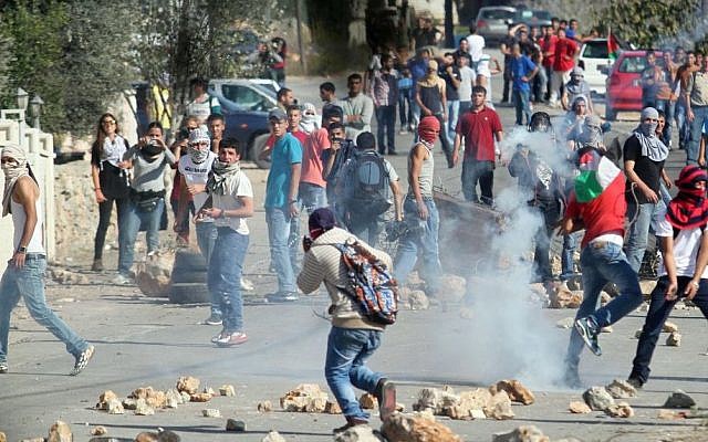 Palestinians clash with Israeli soldiers after the funeral of Palestinian-American, Orwah Hammad, 14, who was shot dead last Friday during clashes with Israeli army soldiers, at the entrance of Hammad's home village of Silwad, near the West Bank city of Ramallah, Sunday Oct. 26, 2014 (photo credit: STR/Flash90)