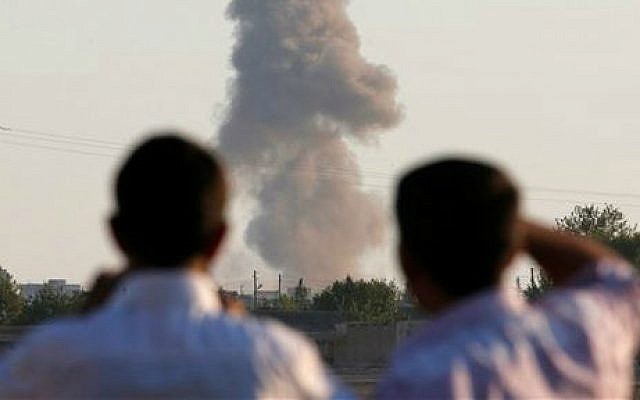 Turkish Kurds standing on the outskirts of Suruc, on the Turkey-Syria border, watch smoke rise following an airstrike in Kobani, Syria, where the fighting between militants of the Islamic State group and Kurdish forces intensified, Tuesday, Oct. 7, 2014 (photo credit: AP/Lefteris Pitarakis) Turkish Kurds standing on the outskirts of Suruc, on the Turkey-Syria border, watch smoke rise following an airstrike in Kobani, Syria, where the fighting between militants of the Islamic State group and Kurdish forces intensified, Tuesday, Oct. 7, 2014 (photo credit: AP/Lefteris Pitarakis)