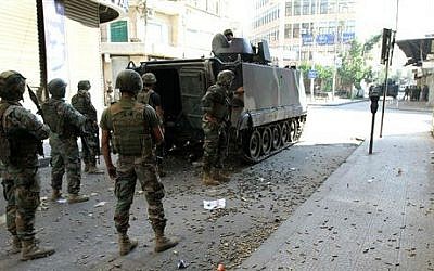 Lebanese army soldiers stand beside an armored vehicle with spent bullet casings littering the ground during clashes with Islamic militants, in the northern port city of Tripoli, Lebanon, Saturday, Oct. 25, 2014 (photo credit: AP)