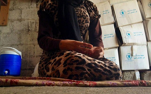 In this photo taken Wednesday, Oct. 8, 2014, a 15-year-old Yazidi girl captured by the Islamic State group and forcibly married to a militant in Syria sits on the floor of a one-room house she now shares with her family after escaping in early August, while speaking in an interview with The Associated Press in Maqluba, a hamlet near the Kurdish city of Dahuk, 260 miles (430 kilometers) northwest of Baghdad, Iraq. (AP Photo/Dalton Bennett) In this photo taken Wednesday, Oct. 8, 2014, a 15-year-old Yazidi girl captured by the Islamic State group and forcibly married to a militant in Syria sits on the floor of a one-room house she now shares with her family after escaping in early August, while speaking in an interview with The Associated Press in Maqluba, a hamlet near the Kurdish city of Dahuk, 260 miles (430 kilometers) northwest of Baghdad, Iraq. (AP Photo/Dalton Bennett)