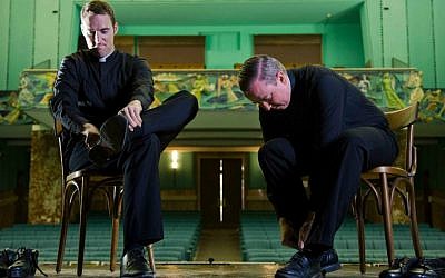 Father David Rider, right, and father John Gibson take their shoes off after dancing before an interview at the Pontifical North American College in Rome. (photo credit: Domenico Stinellis/AP)