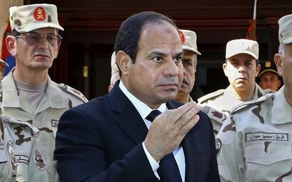 Egyptian President Abdel-Fattah el-Sissi speaks in front of the state-run TV ahead of a military funeral for troops killed in an assault in the Sinai Peninsula, as he stands with army commanders in Cairo, Egypt, October 25, 2014. (photo credit: AP/MENA, Mohammed Samaha)