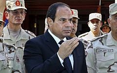 In this photo provided by Egypt's state news agency MENA, Egyptian President Abdel-Fattah el-Sissi speaks in front of the state-run TV ahead of a military funeral for troops killed in an assault in the Sinai Peninsula, as he stands with army commanders in Cairo, Egypt, Saturday, Oct. 25, 2014  (photo credit: AP Photo/MENA, Mohammed Samaha)