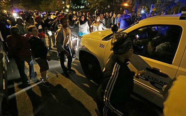 A crowd gathers near the scene in south St. Louis where a man was fatally shot by an off-duty St. Louis police officer on Wednesday, October 8, 2014. (photo credit: AP/St. Louis Post-Dispatch, David Carson) A crowd gathers near the scene in south St. Louis where a man was fatally shot by an off-duty St. Louis police officer on Wednesday, October 8, 2014. (photo credit: AP/St. Louis Post-Dispatch, David Carson)