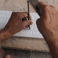 In this photograph taken on August 21, 2014 Indian Muslim tombstone engraver Mohammad Abdul Yaseen, 74, chips inscriptions onto a stone slab at the Bene Israel Jewish cemetery in Mumbai. (photo credit: AFP PHOTO/ INDRANIL MUKHERJEE)