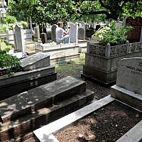 In this photograph taken on August 21, 2014 Indian Muslim tombstone engraver Mohammad Abdul Yaseen, 74, gives a fresh coat of paint onto faded tombstone letterings at the Bene Israel Jewish cemetery in Mumbai. (photo credit: AFP PHOTO/ INDRANIL MUKHERJEE)