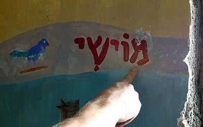 Naftali Charter, the Chief of Security at Nariman (Chabad) House, points to the Hebrew name of the son of slain US Rabbi Gavriel Holtzberg, his Israeli wife Rivka  on a wall in his room, on November 26, 2014. (photo credit: AFP PHOTO/ INDRANIL MUKHERJEE)