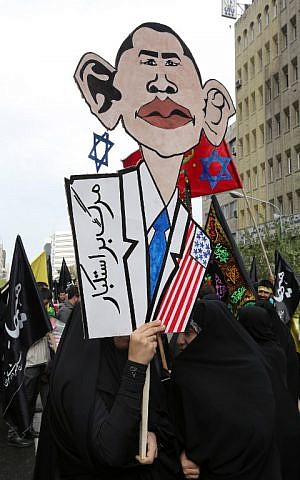 Iranian women hold an anti-US placard bearing an image of US President Barack Obama on November 4, 2014, during a demonstration outside the former US embassy in Tehran to mark the anniversary of its storming by student protesters that triggered a hostage crisis. (photo credit:AFP/ATTA KENARE Iranian women hold an anti-US placard bearing an image of US President Barack Obama on November 4, 2014, during a demonstration outside the former US embassy in Tehran to mark the anniversary of its storming by student protesters that triggered a hostage crisis. (photo credit:AFP/ATTA KENARE