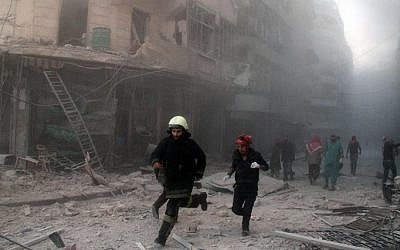 Emergency response teams rush to the scene of a reported barrel bomb attack by government forces in the al-Muasalat area in the northern Syrian city of Aleppo on November 6, 2014. (photo credit: AFP/AMC/Tamer al-Halabi)