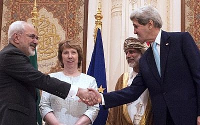 US Secretary of State John Kerry (R) and Iranian Foreign Minister Javad Zarif (L) shake hands as Omani Minister Responsible for Foreign Affairs Yussef bin Alawi (2nd R) and former EU top diplomat Catherine Ashton watch in Muscat on November 9, 2014. (photo credit: AFP PHOTO/NICHOLAS KAMM/POOL)