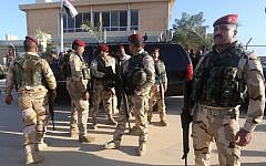 Iraqi army soldiers stand before a conference on fighting the Islamic State group attended by Iraq's tribal leaders, militiamen and members of the government, at the Al-Asad air base, in Iraq's mainly Sunni Anbar province, on November 11, 2014.  (photo credit: AFP/Ahmad al-Rubaye)