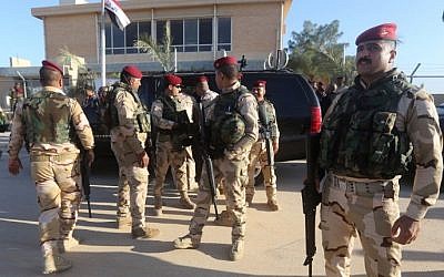 Iraqi army soldiers stand before a conference on fighting the Islamic State group attended by Iraq's tribal leaders, militiamen and members of the government, at the Al-Asad air base, in Iraq's mainly Sunni Anbar province, on November 11, 2014.  (photo credit: AFP/Ahmad al-Rubaye)
