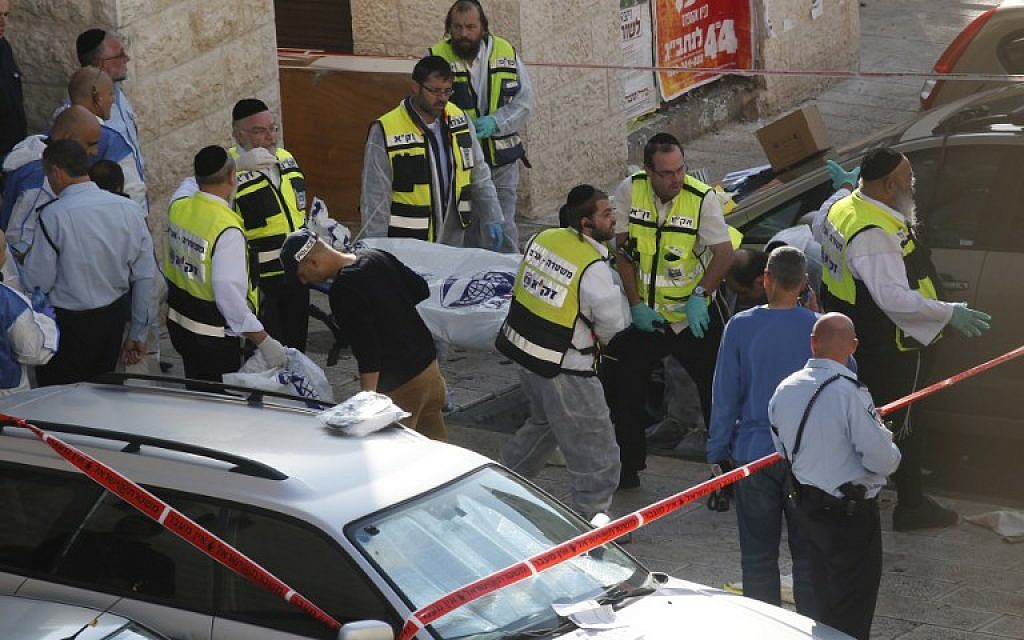 Israeli Zaka emergency services volunteers carry the body of a Palestinian assailant who was shot dead while attacking a synagogue in Jerusalem on November 18, 2014. (photo credit: AFP / GALI TIBBON)